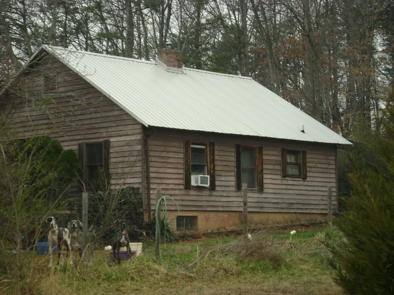 White metal roof on an old wood sided farmhouse, from a Metal Roof Installation job in Atwood